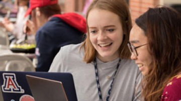 Two students looking at a laptop